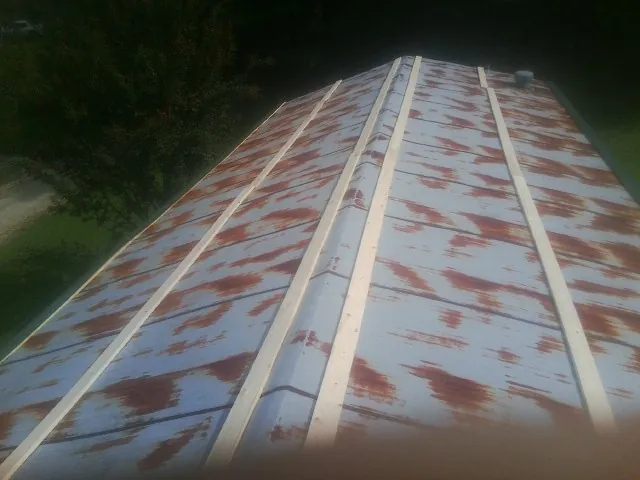 Rusted metal roof panels with new wood purlins before replacement — Storm Damage Roof Repair in Markleton by Roofing Brothers