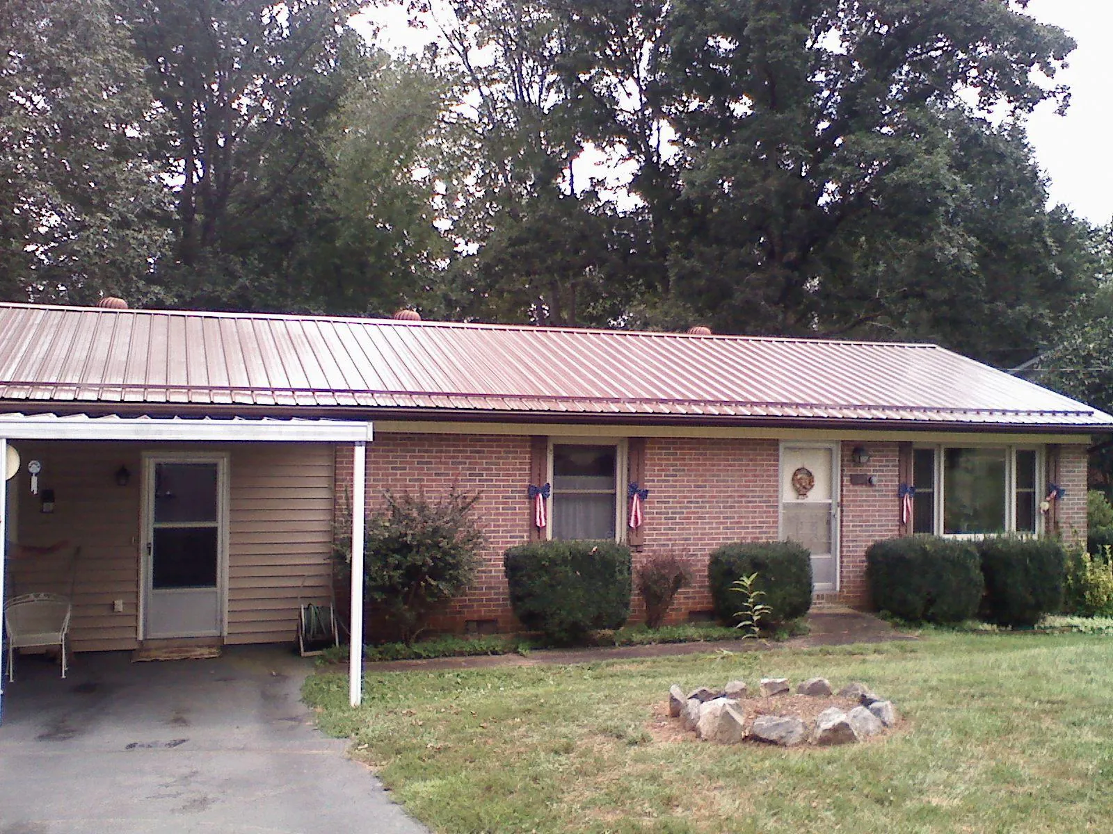 Bronze metal roof and carport on a brick ranch home — Roof Repair work by our crew in Markleton